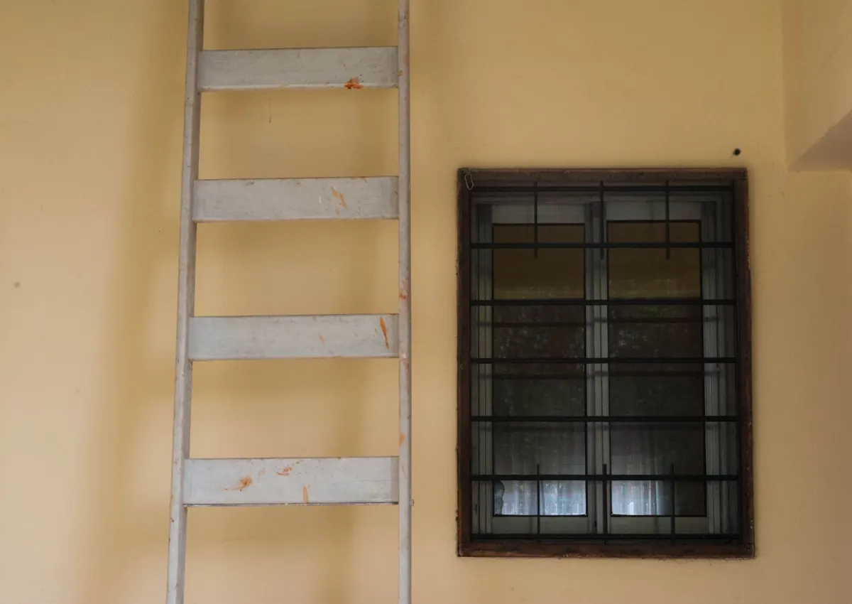 Aluminium-Anlegeleiter an einer gelben Hauswand